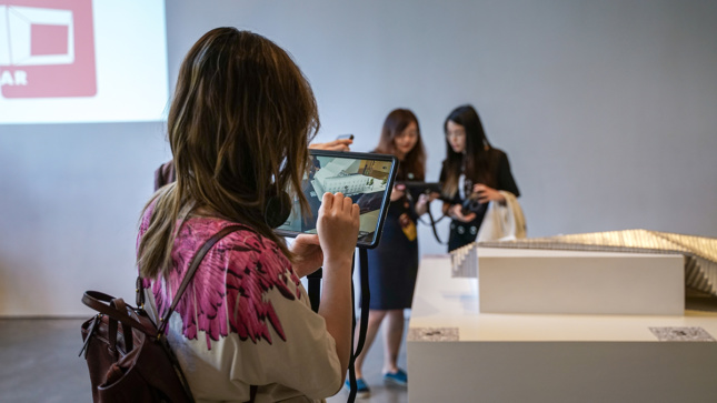 People using iPads in a museum space.