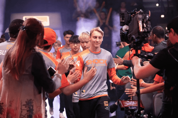 Grant "moth" Espe walks down an aisle in the Overwatch League arena with his fellow San Francisco Shock teammates and high fives fans
