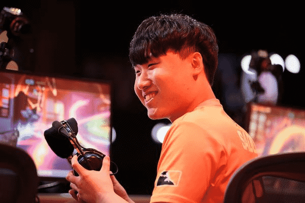 Su-min "SADO" Kim smiles, putting on his headset as he gets ready for a game in the Overwatch League