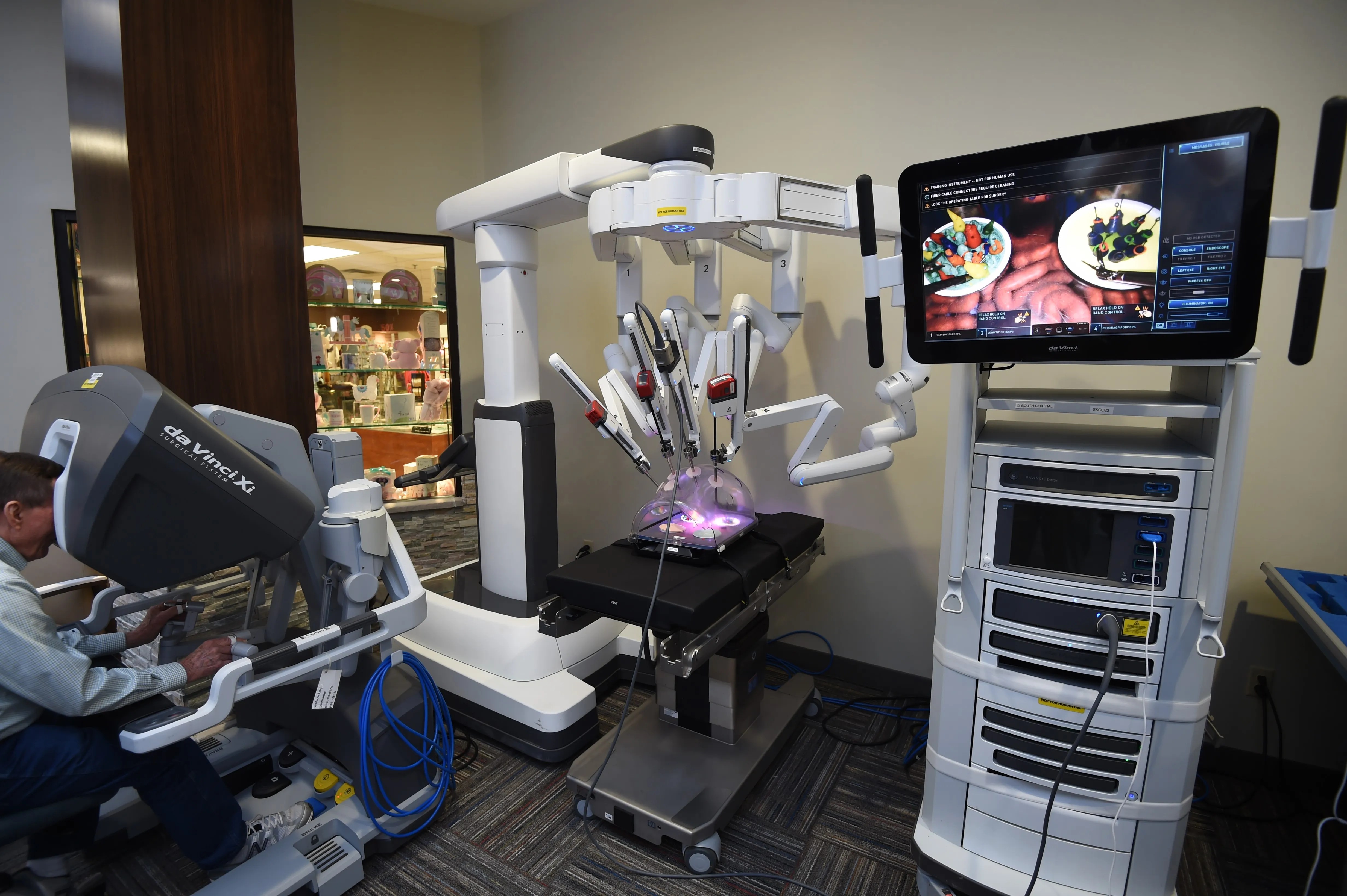A visitor tries to operate the da Vinci Xi surgical system on display at Baxter Regional Medical Center on Tuesday afternoon. The hospital recently purchased a da Vinci Xi system identical to the one displayed. The da Vinci systems are called "medical robots," but they are not autonomous and require a human to control it.