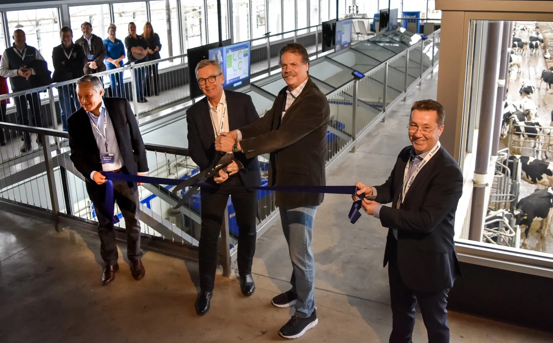 Joakim Rosengren, president and CEO of DeLaval, second from left, and Mike McCloskey, co-founder of Fair Oaks Farms, second from right, during a ribbon cutting ceremony in November 2019 to announce the opening of a new robot barn and visitor area at the dairy facility.