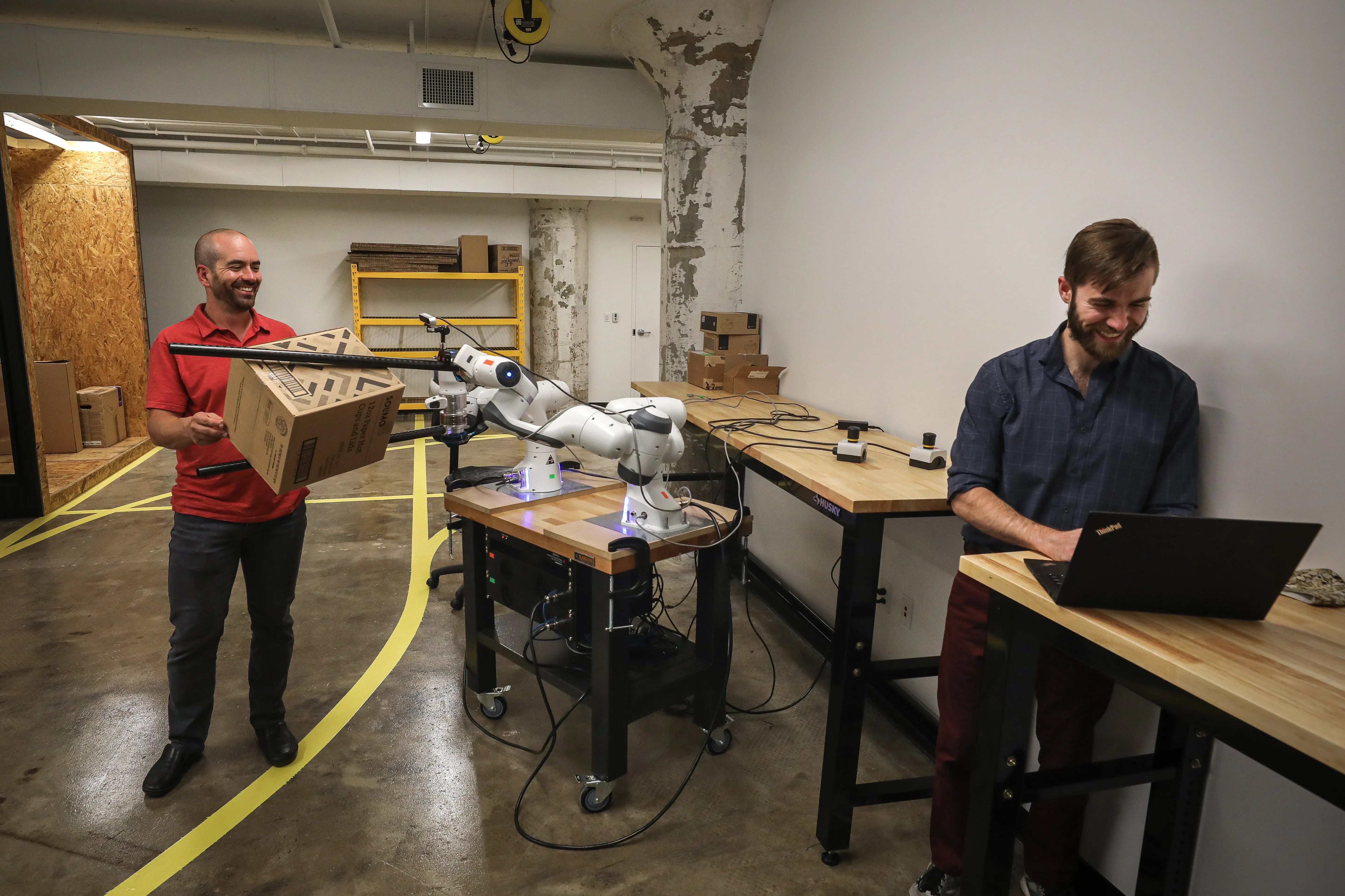 Dextrous Robotics co-founders Evan Drumwright (left) and Sam Zapolsky (right) work inside the company's research lab at Crosstown Concourse in Memphis. It's developing a robot that can handle heavy packages at high speeds.