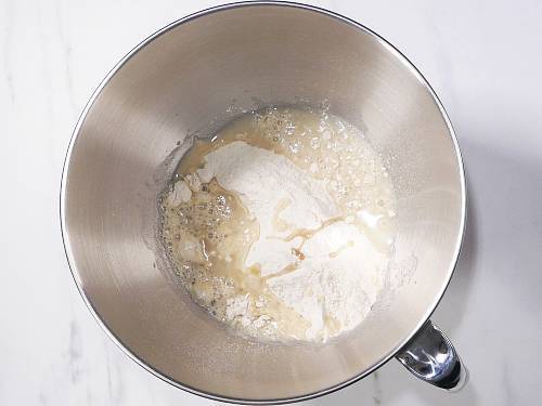adding flour water oil to bowl to make dough