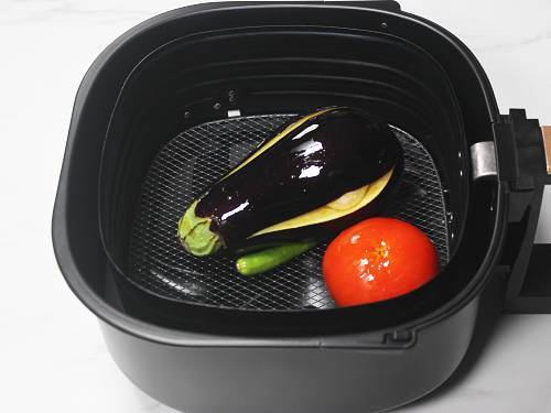 eggplants garlic tomatoes chilies in air fryer basket