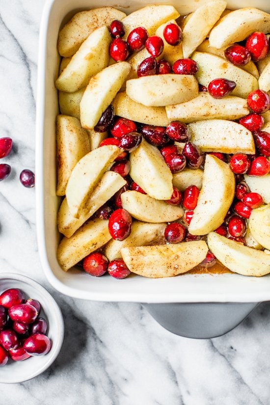 apples and cranberries in a baking dish.